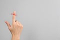 Woman showing index finger with tied red bow as reminder on light grey background, closeup. Space for text Royalty Free Stock Photo