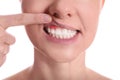 Woman showing inflamed gums on white background, closeup view