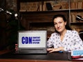 Woman showing laptop computer with CDN CONTENT DELIVERY SYSTEM icon on screen background, success in business concept