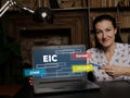 Woman showing laptop computer with EIC Earned Income Credit icon on screen background, success in business concept