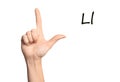 Woman showing letter L on background, closeup. Sign language