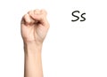 Woman showing letter S on background, closeup. Sign language