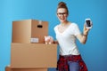 Woman showing mobile phone blank screen near cardboard box with Royalty Free Stock Photo