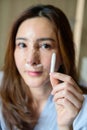 Woman showing old silicone from her nose after revision rhinoplasty