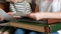 Woman is showing pictures of the family to her child and is telling him about his forebearers