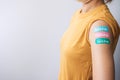 Woman showing plaster after receiving covid 19 vaccine. Vaccination, herd immunity, side effect, booster dose, vaccine passport