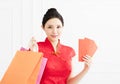 Woman showing the red envelope and shopping bags