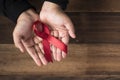 Woman showing red ribbon AIDS ribbon .