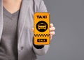 Woman showing smartphone with taxi app interface