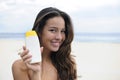 Woman showing suncream at the beach