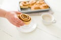 Woman showing a sweet roll with cinnamon and sugar Royalty Free Stock Photo