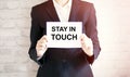 Woman showing white card with STAY IN TOUCH word . Business Royalty Free Stock Photo