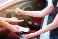 Woman in showroom giving dollars money and taking keys from car Royalty Free Stock Photo