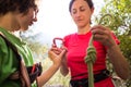 A woman shows a child how to use a carabiner for belaying, carabiner and safety harness