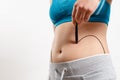 A woman shows a dotted line on her body liposuction zone Royalty Free Stock Photo