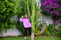 A woman shows her hands from behind a tall cactus Royalty Free Stock Photo