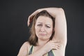 Unhappy woman shows her unshaved armpit. plus size middle age woman is not happy with hair in her armpits. Caucasian girl is Royalty Free Stock Photo