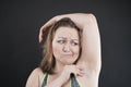 Unhappy woman shows her unshaved armpit. plus size middle age woman is not happy with hair in her armpits. Caucasian girl is Royalty Free Stock Photo