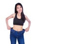 Woman shows her weight loss and wearing her old jeans isolated o Royalty Free Stock Photo