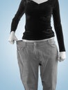 Woman shows her weight loss by wearing an old big trousers. Royalty Free Stock Photo