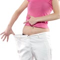 Woman shows her weight loss by wearing an old big trousers. Royalty Free Stock Photo