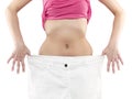 Woman shows her weight loss by wearing an old big trousers. Royalty Free Stock Photo