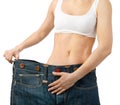 Woman shows her weight loss by wearing an old jeans, isolated on Royalty Free Stock Photo