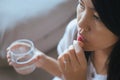 Woman sick with capsules putting in her mouth,female taking medicines and a glass of water Royalty Free Stock Photo