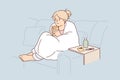 Woman sick with flu wrapped in blanket sits on couch and drinks hot decoction of herbs