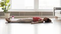 Woman side view lying on yoga mat practicing corpse pose Royalty Free Stock Photo