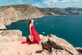 A woman, a side view in a red flying dress fluttering in the wind, a girl in a fluttering dress on the background of the Royalty Free Stock Photo