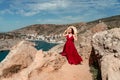 A woman, a side view in a red flying dress fluttering in the wind, a girl in a fluttering dress on the background of the Royalty Free Stock Photo