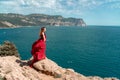 A woman, a side view in a red flying dress fluttering in the wind, a girl in a fluttering dress on the background of the Royalty Free Stock Photo