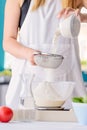 Woman sifting flour through sieve. Royalty Free Stock Photo