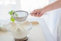 Woman sifting flour through sieve. Royalty Free Stock Photo