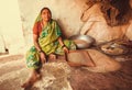 Woman sifting grain at her rural house in indian village