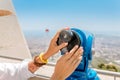 woman sightseeing in city vacation using telescope viewer Royalty Free Stock Photo