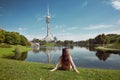 Woman sightseeing in Olympiapark, Munich. Brunette sitting on th