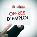 Woman with a signboard with the text offres d'emploi, jobs in fr