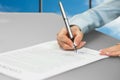 Woman signing contract near window. Royalty Free Stock Photo