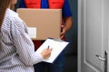 Woman signing for delivered parcel on doorstep Royalty Free Stock Photo