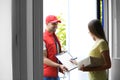 Woman signing for delivered parcel. Courier service Royalty Free Stock Photo