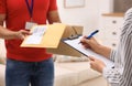 Woman signing for delivered parcels at home. Courier service Royalty Free Stock Photo