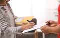 Woman signing for delivered parcels at home. Courier service Royalty Free Stock Photo