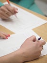 Female hand holding pen and paper on table. Royalty Free Stock Photo