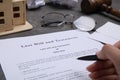 Woman signing last will and testament at grey table, closeup Royalty Free Stock Photo