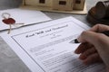 Woman signing last will and testament at light grey table, closeup Royalty Free Stock Photo
