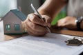 Woman signing loan agreement to buy house through bank broker Royalty Free Stock Photo