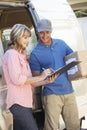 Woman Signing For Packager Delivered By Courier Royalty Free Stock Photo