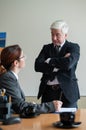 The woman signs the contract. Mature man indicates where the girl put a signature. Royalty Free Stock Photo